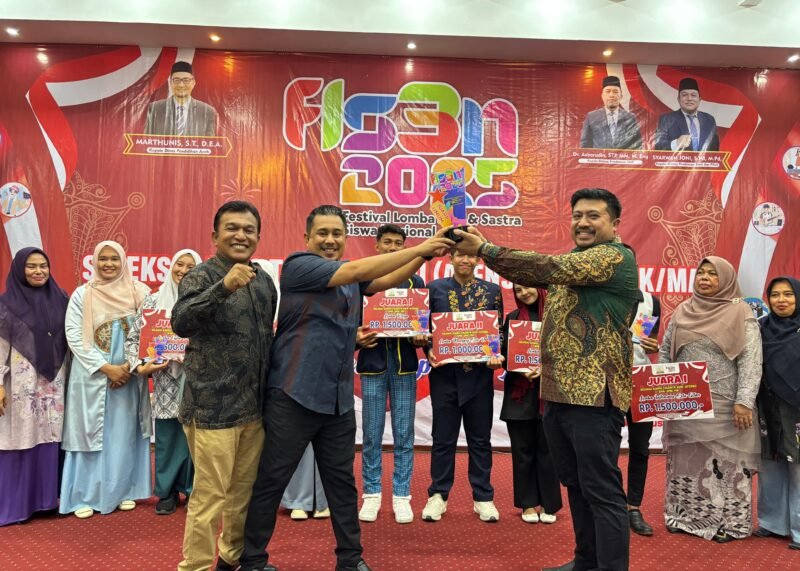 Sekretaris Dinas Pendidikan Aceh, Sabri, S STP., M.SP didampingi Kepala Bidang SMA dan PKLK, Syarwan Joni, S.Pd., M.Pd menyerahkan trofi juara umum pada pemenang pada malam penutupan ATENSI 2025. Foto: Dok. Humas Disdik Aceh