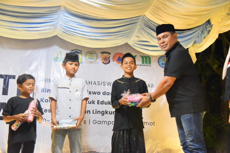 Bupati Aceh Besar Muharram Idris bagikan hadiah lomba Bakti Sosial PP HIMAB di Halaman Masjid Darul Muttaqin, Gampong Lamtamot, Minggu (23/8/2025) malam. Foto: Dok. MC Aceh Besar