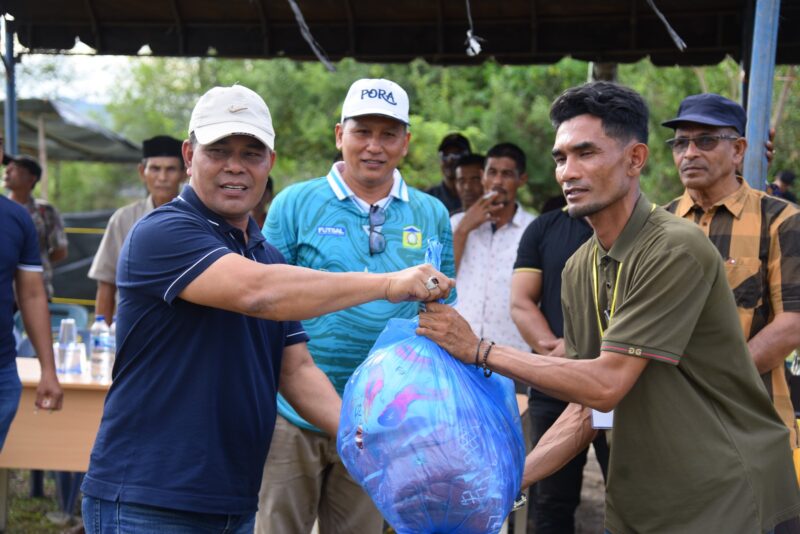 Bupati Aceh Besar H Muharram Idris (Syech Muharram), di dampingi Kadisparpora Aceh Besar Abdullah SSos, menyerahkan peralatan olahraga kepada panitia pelaksana turnamen sepakbola HUT ke-30 Kemukiman Lamteuba, di Lapangan Keumeureuk, Gampong Lam Apeng, Kemukiman Lamteuba, Kecamatan Seulimeuem, Kabupaten Aceh Besar, Sabtu (23/8/2025). Foto: Dok. MC Aceh Besar