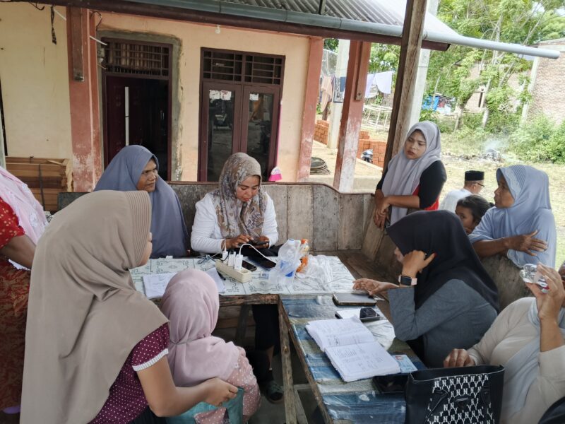 Warga Gampong Batee, saat menerima uang dari petugas pendaftaran aplikasi dana, Minggu (3/8/2025) (Foto.Amir Sagita.NOA.co.id).