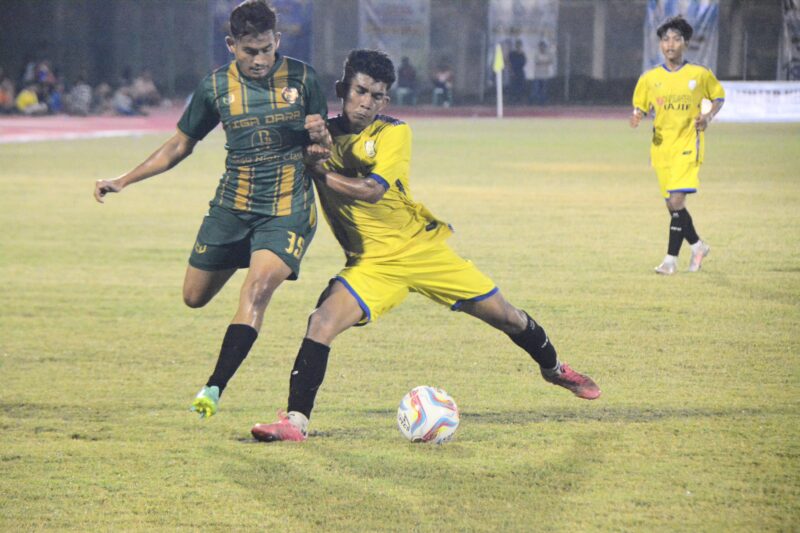 Pemain Persimura memakai kustim warna kuning berebut bola degan pemain CST Ulim Pidie Jaya pada pertandingan Piala Bupati Pidie, di Stadion Blang Paseh Kota Sigli, Sabtu malam (27/9/2025) (Foto.Amir Sagita.NOA.co.id).