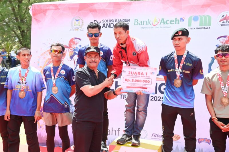 Wakil Bupati Aceh Besar Drs H Syukri A Jalil menyerahkan hadiah kepada pemenang lomba Trail Running 2025 di Pantai Teubing Lampuuk, Kecamatan Lhoknga, Aceh Besar, Minggu (31/08/2025). Foto: Dok. MC Aceh Besar