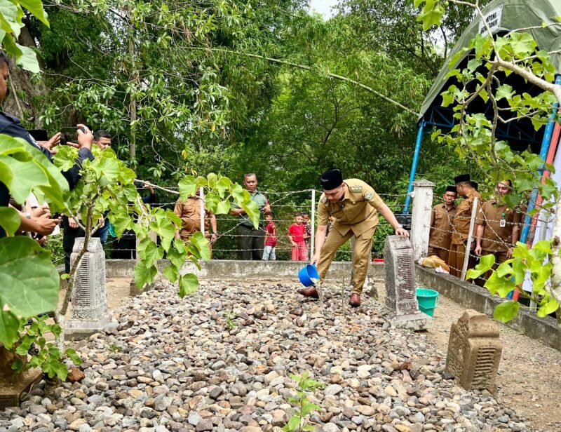 Wabup Pidie, Alzaizi Umar sedang menyiram air di makam Raja Pedir di Gampong Dayah Tanoh, Klibuet, Kecamatan Pidie, Senin (15/9/2025) (Foto.Amir Sagita.NOA.co.id).