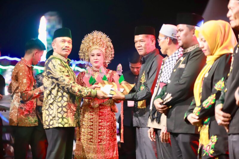 Bupati Pidie, Sarjani Abdullah menyerahkan piagam penghargaan kepada budayawan, Musmarwan Abdullah pada acara penutupan urou lahe Pidie ke 514 di Gedung PCC Sigli, Sabtu (20/9/2025). ( Foto.Amir Sagita.NOA.co.id).