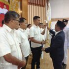 Ketua KONI Pidie, Muhammad menerima bendera dari Plt Ketua KONI Aceh Tgk Anwar Ramli pada pelantikan Pengurus KONI Pidie, di Balee Meusapat Ureunv Pidie, Kamis (11/9/2025) (Foto.Amir Sagita.NOA.co).