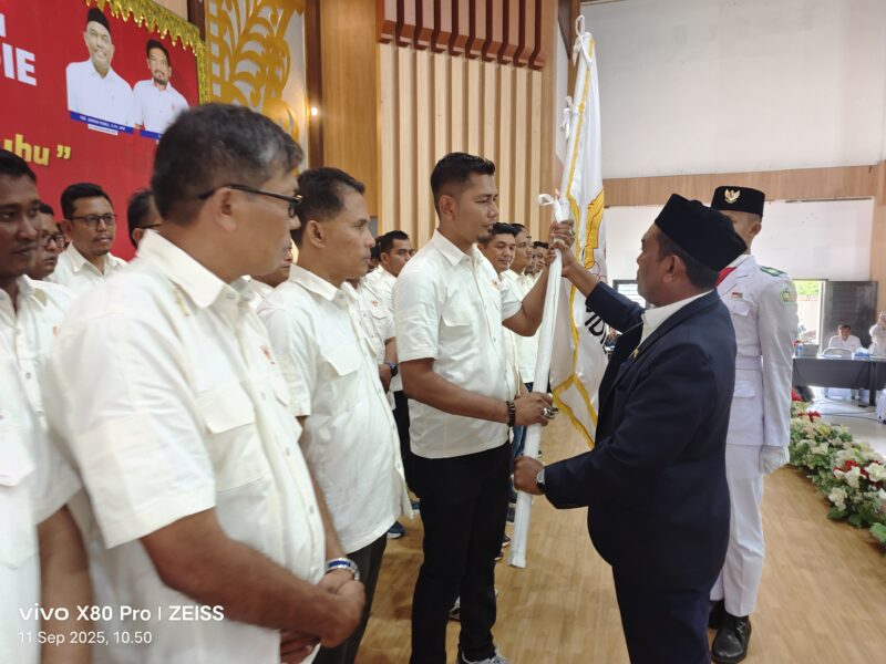 Ketua KONI Pidie, Muhammad menerima bendera dari Plt Ketua KONI Aceh Tgk Anwar Ramli pada pelantikan Pengurus KONI Pidie, di Balee Meusapat Ureunv Pidie, Kamis (11/9/2025) (Foto.Amir Sagita.NOA.co).