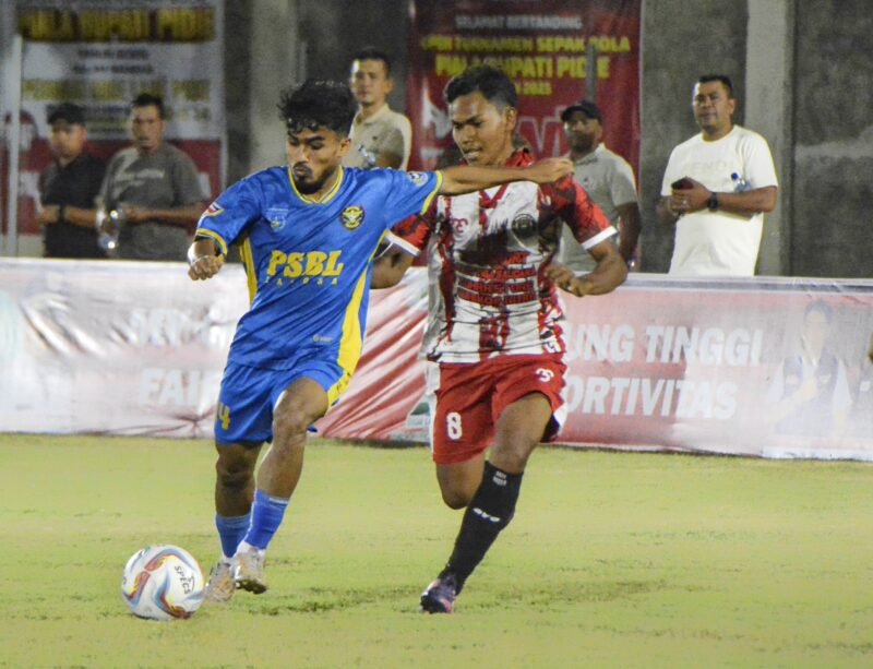 Pemain PSBL Langsa menggiring bola dan dibayang bayangi pemain Akhyar GLD Padang Tiji, Pidie pada pertandingan lanjutan Piala Bupati Pidie, di Stadion Blang Paseh Kota Sigli, Minggu malam (28/9/2025) (Amir Sagita.NOA.co.id).