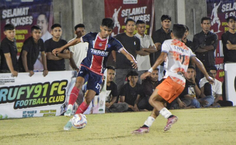 Pemain Derre FC Aceh Utara menggiring bola dan dibayang bayangi pemain L Patra Bireuen pada pertandingan Piala Bupati Pidie di Stadion Blang Paseh Kota Sigli, Senin malam (6/10/2025) (Foto.Amir Sagita NOA.co.id).