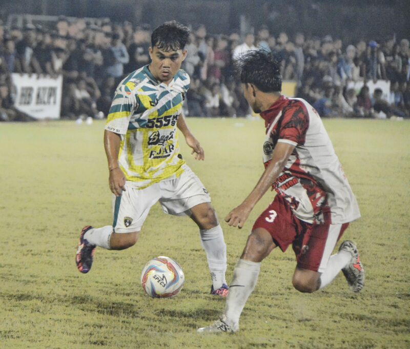 Pemain Rufi 91 FC menggiring bola dan dibayang bayangi pemain Akhyar GLD Padang Tiji pada lanjutan babak delapan besar Piala Bupati Pidie di Sta dion Blang Paseh Kota Sigli, Selasa malam (7/10/2025) (Foto.Amir Sagita.NOA.co.id).