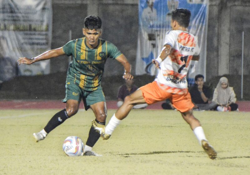 Pemain CST Ulim Pidie Jaya menggiring bola dan dihadang pemain L.Patra Kabupaten Bireuen pada pertandingan semifinal Piala Bupati Pidie di Stadion Blang Paseh Kota Sigli Kabupaten Pidie, Jumat malam (10/10/2025) (Foto.Amir Sagita.NOA.co.id).