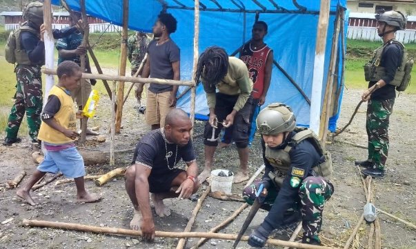 Personel Pos ILU Satgas Yonif 112/DJ bergotong royong bersama masyarakat mempersiapkan perlombaan dalam rangka menyambut Hari Natal di Distrik ILU, Kabupaten Puncak Jaya, Papua Tengah, Minggu (16/11/2025). Foto: Dok. Istimewa