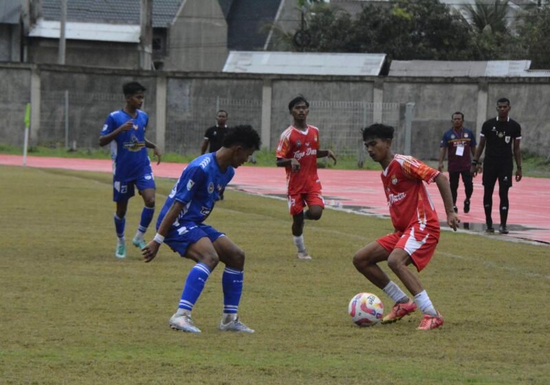 Pemain Persimura Beureunuen memakai kostum warna merah menggiring bola dan dikawal sejumlah pemain PSAP Sigli pada laga pamungkas di Stadion Blang Paseh Kota Sigli Kabupaten Pidie, Minggu (23/11/2025) (Foto.Amir Sagita.NOA.co.id).