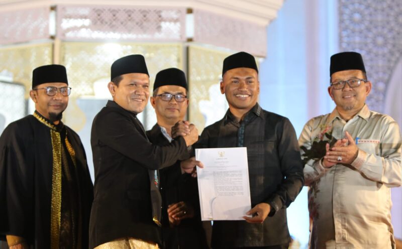 Wakil Gubernur Aceh, Fadhlullah, menyerahkan SK penetapan tuan rumah MTQ Aceh ke-38 kepada Bupati Abdya, Safaruddin, pada malam penutupan MTQ ke-37 di Pidie Jaya, Jumat (7/11/2025). Foto: Dok. Setdakab Abdya