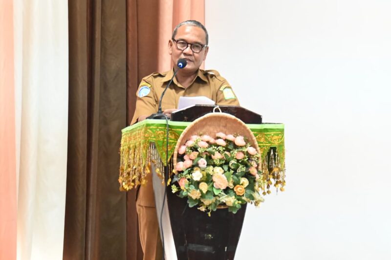 Plt. Kadiskominfo Aceh Besar, Muzakkir SE menyampaikan laporan panitia dalam acara Bimtek e-office Surat Menyurat bagi Aparatur Gampong di Gedung Dekranasda Aceh Besae, Gampong Gani, Kecamatan Ingin Jaya, Aceh Besar, Selasa (16/12/2025). Foto: Dok. MC Aceh Besar