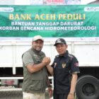 Direktur Utama Bank Aceh Syariah Fadhil Ilyas menyerahkan bantuan sembako secara simbolis kepada Bupati Pidie Jaya Tgk H Syibral Malasyi di Posko Utama Penanganan Banjir Pidie Jaya, Sabtu (13/12/2025). Foto: Dok. Istimewa