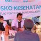 Petugas BSI memberikan pemeriksaan kesehatan gratis kepada warga terdampak banjir di Posko Kesehatan Kanca Kuala Simpang. Foto: Dok. Istimewa