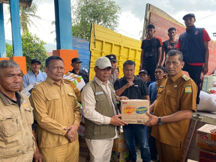 Bupati Aceh Besar H. Muharram Idris menerima bantuan kemanusiaan dari masyarakat Seulimuem yang diserahkan Camat Seulimuem di Gudang Logistik BPBD Aceh Besar, Senin (8/12/2025). Foto: Dok. MC Aceh Besar
