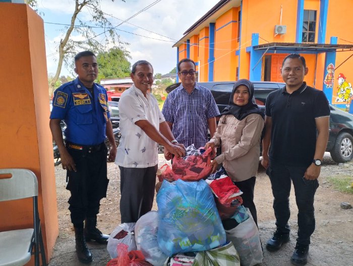 Kepala Diskominfo Aceh Besar Muzakkir, SE menyerahkan bantuan pakaian layak pakai kepada posko tanggap darurat di Sibreh Keumude, Kecamatan Sukamakmur, Jumat (5/12/2025). Foto: Dok. Pemkab Aceh Besar