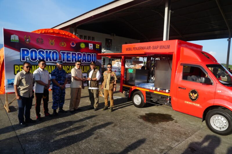 Menko Polkam RI Jenderal TNI (Purn) Djamari Chaniago (Ketiga Kanan) saat Penyerahan secara simbolis mobil penjernih air bantuan dari Kemenko Polkam pada BNPB yang diterima Deputi Bidang Rehabilitasi dan Rekonstruksi, Jarwansah di Posko Pendampingan BNPB, Shelter Galaxy Lapangan Udara Sultan Iskandar Muda, Sabtu (13/12/2025). (Foto : NOA.co.id/HO-Kemenko Polkam RI).