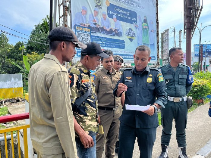 Petugas Satpol PP dan WH Aceh Besar melakukan penertiban aksi penggalangan dana tanpa izin di Simpang Bundaran Lambaro, Senin (19/1/2026). Foto: Dok. MC Aceh Besar