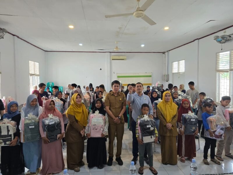 Anggota DPRK Banda Aceh, Faisal Ridha, menyerahkan peralatan sekolah kepada anak yatim di Aula Kantor Camat Jaya Baru, Selasa (16/12/2025). Foto: Dok. Istimewa