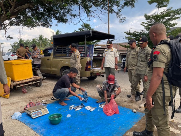 Petugas Satpol PP dan WH Aceh Besar memberikan imbauan secara humanis kepada PKL yang berjualan di kawasan Jembatan Lambaro, Kecamatan Ingin Jaya, Senin (26/1/2026). Foto: Dok. MC Aceh Besar