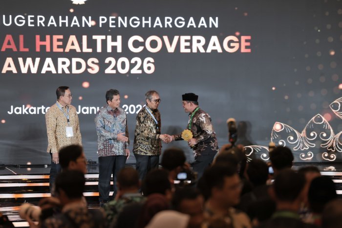 Bupati Aceh Besar H. Muharram Idris (Syech Muharram) menerima penghargaan Universal Health Coverage (UHC) kategori Utama dari Dirut BPJS Kesehatan Ali Ghufron Mukti di JIExpo Kemayoran, Jakarta, Selasa (27/1/2026). Foto: Dok. Prokopim Pemkab Aceh Besar
