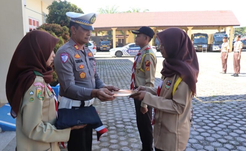 Kapolres Aceh Barat Daya AKBP Agus Sulistianto, S.H., S.I.K. melalui Kasat Lantas Polres Abdya AKP T. Tasrizalsyah menyerahkan piagam dan wing keselamatan kepada anggota Pramuka Saka Bhayangkara di Mapolres setempat. Foto. Dok. Teukunizar/NOA.co.id
