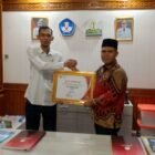 Ketua Komisi Informasi Aceh Junaidi menyerahkan sertifikat dan plakat penghargaan kualifikasi Informatif kepada Plt Kepala Dinas Pendidikan Aceh Murthalamuddin. Foto: Dok. Istimewa