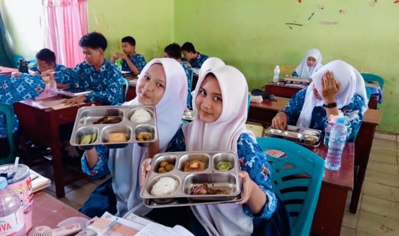 Siswa menunjukkan menu makanan yang disediakan oleh Pemerintah melalui program MBG. Foto: MtsPalembang