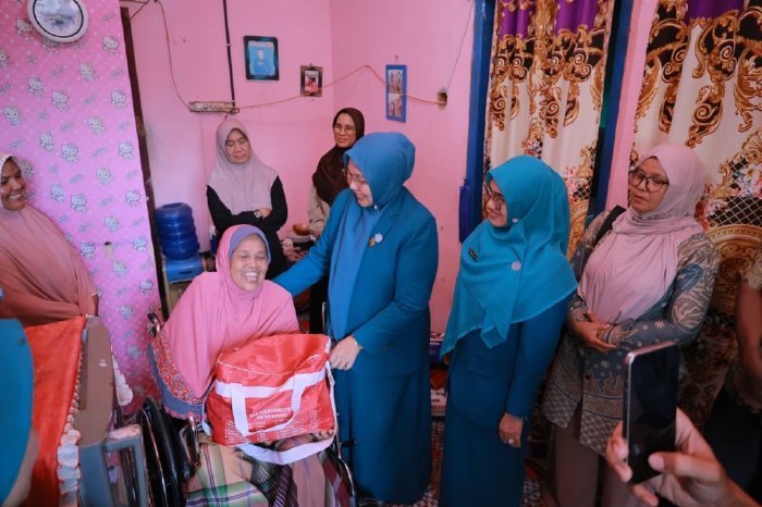 Ketua TP-PKK Aceh Besar, Hj. Rita Mayasari, menyerahkan kursi roda dan paket sembako secara langsung kepada Nismawati, warga penyandang disabilitas di Gampong Meunasah Tunong, Kecamatan Seulimeum, Kamis (12/2/2026). Foto: Dok. MC Aceh Besar