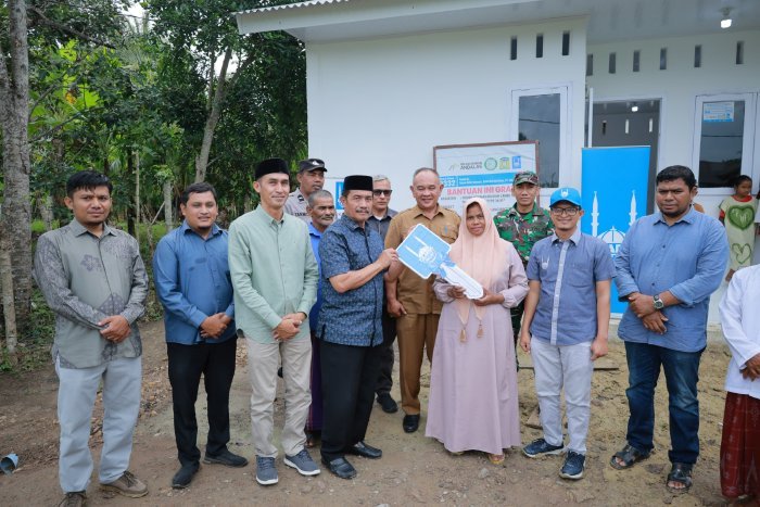 Wakil Bupati Aceh Besar Syukri A Jalil menyerahkan secara simbolis kunci rumah dhuafa tahan gempa tipe 36 kepada penerima manfaat di Kecamatan Blang Bintang, Senin (16/02/2026). Foto: Dok. MC Aceh Besar