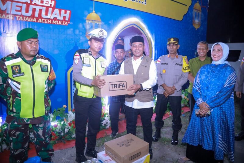 Bupati Aceh Besar H. Muharram Idris menyerahkan logistik ke personel Pospam Bundaran Lambaro, Kecamatan Ingin Jaya, Kamis (18/3/2026) malam. Foto: Prokopim Aceh Besar
