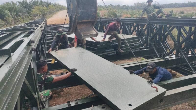 Personel Batalyon Zeni Tempur 16/Dhika Anoraga memasang plat lantai Jembatan Bailey di Kecamatan Lhoksukon, Aceh Utara, Selasa (3/3/2026). Foto: Dok. Istimewa