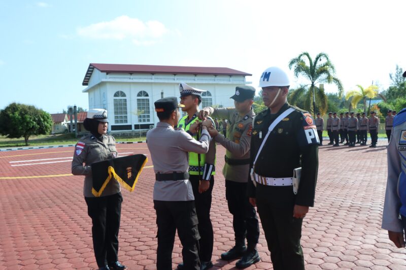 Kapolres Aceh Jaya Zulfa Renaldo menyematkan pinta tanda operasi kepada personel saat Apel Gelar Pasukan Operasi Ketupat Seulawah 2026 di halaman Mapolres Aceh Jaya, Kamis (12/03/2026). Foto: Dok. Polres Aceh Jaya