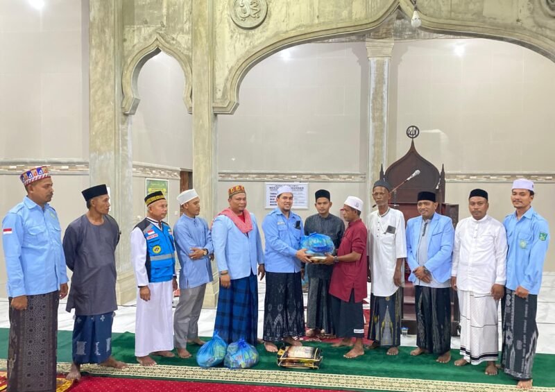 Sekretaris Umum DPD BKPRMI Aceh Timur, Tgk Ismuhadi, MSM, menyerahkan bantuan sembako ke Marbot Masjid Baitul Manan Matang Pineung Idi Cut, Tgk Muhammad Isa, dalam kunjungan Safari Ramadan di Gampong Matang Pineung, Kec. Darul Aman, Kab. Aceh Timur, Senin (2/3/2026) malam. Foto (Dok. Humas BKPRMI Aceh Timur)
