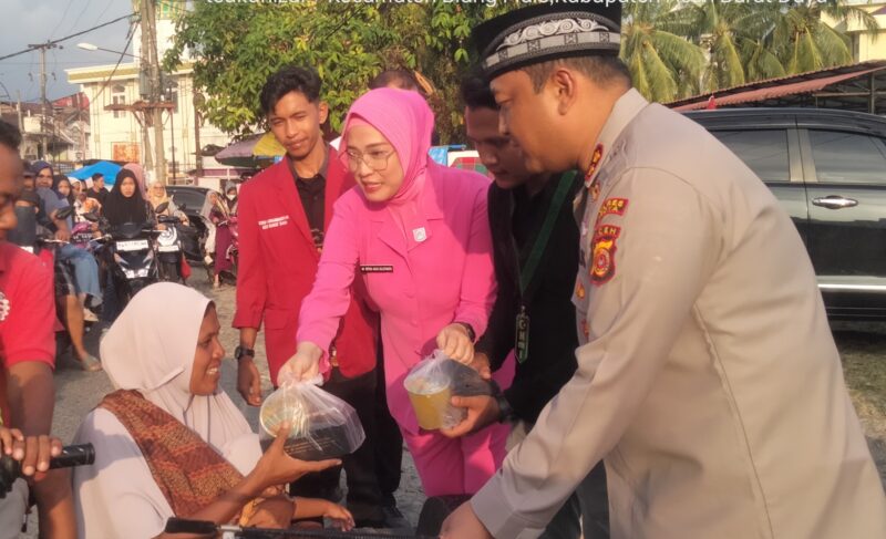 Ketua Bhayangkari Cabang Polres Abdya, Ny. Retno Agus Sulistianto bersama Kapolres AKBP Agus Sulistianto memberikan paket takjil kepada warga yang lewat. Foto. Dok. Teukunizar/NOA.co.id