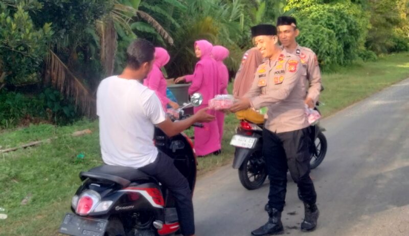Kapolsubsektor Jeumpa IPDA Prawiro Djoko S membagikan paket takjil kepada pengguna jalan. Foto. Dok. Teukunizar/NOA.co.id