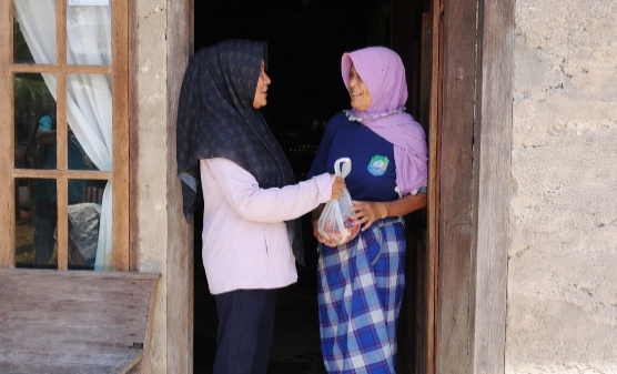 Keuchik Gampong Lamkuta, Thaibah menyerahkan langsung daging meugang gratis kepada warga. Foto. Dok. Teukunizar/NOA.co.id.
