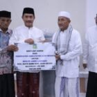 Wakil Bupati Aceh Besar Drs Syukri A Jalil menyerahkan bantuan 150 sak semen dan ambal sajadah kepada pengurus Masjid Jamik Lamrabo saat Safari Ramadhan di Gampong Deyah, Kecamatan Kuta Baro, Minggu (1/3/2026). Foto: Dok. MC Aceh Besar