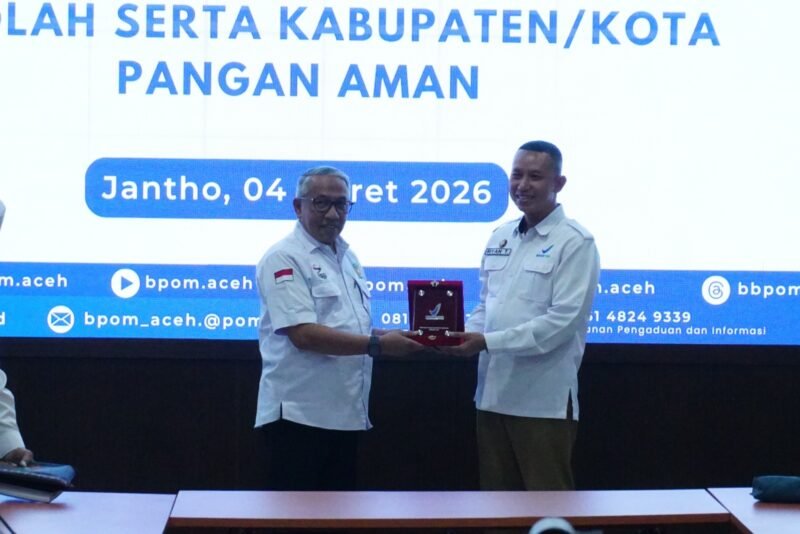 Asisten I Sekdakab Farhan AP, menyerahkan Cinderamata kepada Kepala BBPOM Aceh pada Forum Advokasi Komitmen Pemda dan Lintas Sektor pada Program Desa, Pasar, Sekolah dan Kabupaten Pangan Aman yang dilaksanakan di Aula Kantor Bupati di Kota Jantho, Rabu (04/03/2026). Foto: Dok. MC Aceh Besar