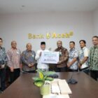 Direktur Utama Bank Aceh Fadhil Ilyas menyerahkan secara simbolis zakat karyawan Bank Aceh Syariah kepada Baitul Mal Aceh di Kantor Pusat Bank Aceh, Banda Aceh, Kamis (12/3/2026). Foto: Dok. Istimewa