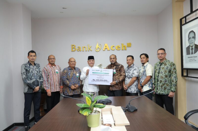 Direktur Utama Bank Aceh Fadhil Ilyas menyerahkan secara simbolis zakat karyawan Bank Aceh Syariah kepada Baitul Mal Aceh di Kantor Pusat Bank Aceh, Banda Aceh, Kamis (12/3/2026). Foto: Dok. Istimewa