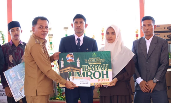 Wakil Bupati Aceh Selatan Baital Mukadis (kiri) didampingi Owner AlifaLand, Aidil Mashendra (tengah) menyerahkan hadiah umroh kepada pemenang. Foto: Dok. AlifaLand