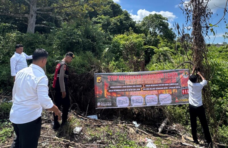 Petugas dari Kepolisian memasang spanduk larangan membakar lahan. Foto. Dok. Teukunizar/NOA.co.id.