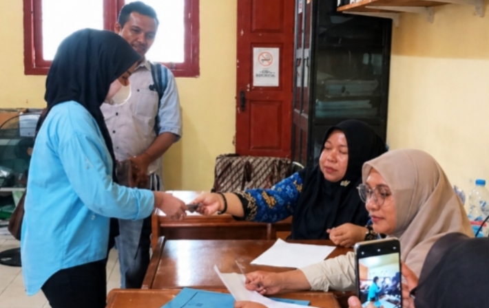 Salah seorang pelaku UMKM di lokasi tepat leumang saat menerima subsidi uang tunai dari Bupati Safaruddi yang disalurkan pihak Dinas perindagkop dan UMKM Abdya. Foto. Dok. Teukunizar/NOA.co.id