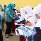 Bunda Guru Aceh, Ny. Marlina Muzakir, didampingi Ketua Dharma Wanita Persatuan Aceh Ny. Malahayati M. Nasir, membagikan paket seragam sekolah dan paket olahan serba ikan kepada Sisea-Siswi di SD Negeri Tanah Rata, Aceh Timur, Rabu (15/4/2026). Foto: Dok. Biro Adpim Setda Aceh