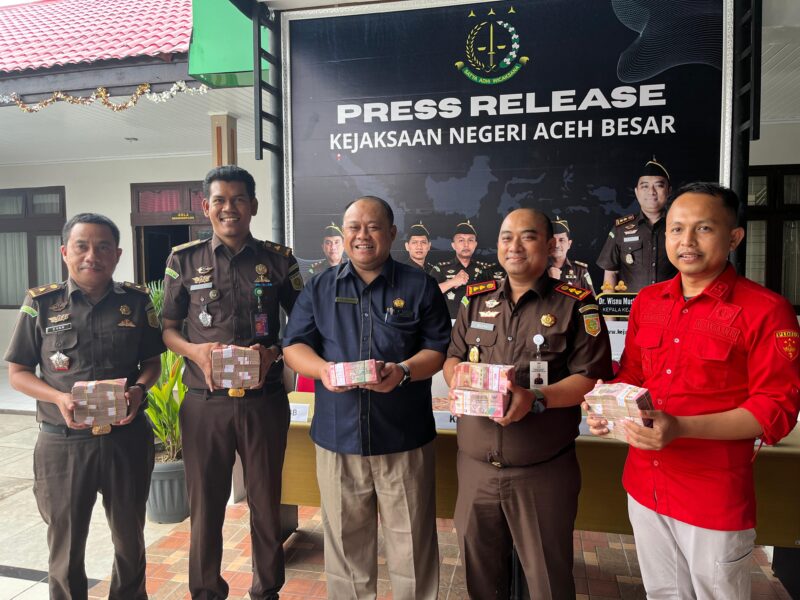 Kepala Kejaksaan Negeri Aceh Besar Dr. Wisnu Murtopo Nur Muhamad, S.H., M.H didampingi Kasi Intel, Kasi Pidsus dan jajarannya menyerahkan sejumlah uang kontak hasil penindakan hukum terhadap dia kasus korupsi di Aceh Besar kepada Kepala KPPN Banda Aceh, Afifudin, pada kegiatan Press Realise Kejari Aceh Besar di Kota Jantho, Rabu (13/5/2026). Foto: Ist