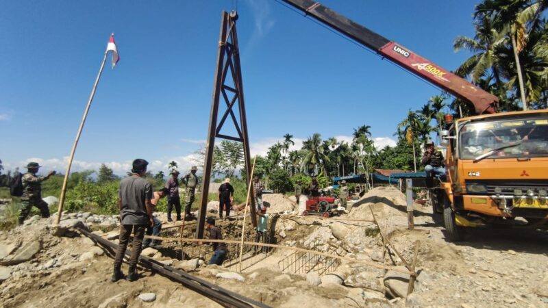 Babinsa Posramil Lawe Sumur bersama warga Desa Teger Miko melakukan pemasangan tiang pancang jembatan gantung perintis yang akan mempermudah akses masyarakat menuju kawasan perkebunan di Kecamatan Lawe Sumur, Aceh Tenggara, Jumat (29/5/2026). Foto: Dok. Istimewa 