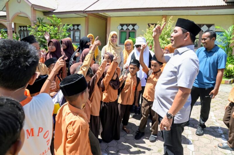 Bupati Aceh Besar, H Muharram Idris berbincang akrab dengan murid saat berkunjung di SDN Limpok, Darussalam, Aceh Besar, Jumat (08/05/2026). Foto: Dok. MC Aceh Besar